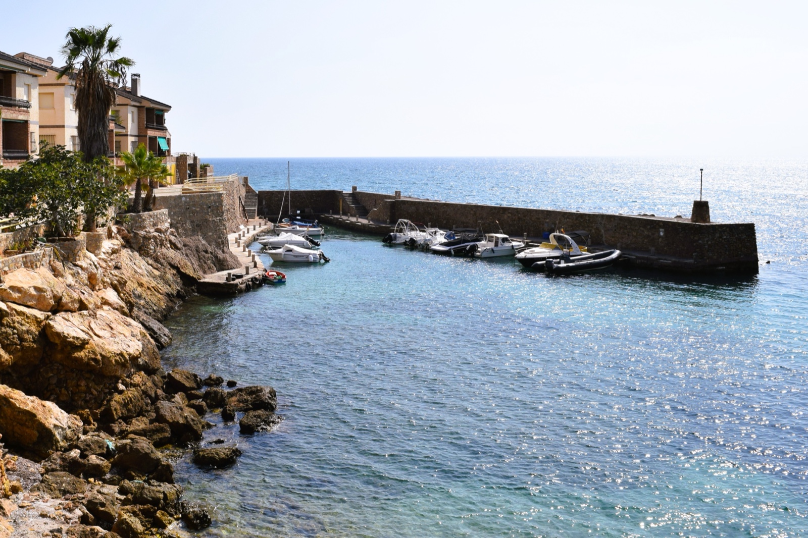 The little stone-walled harbour at Isla Plana with moored boats