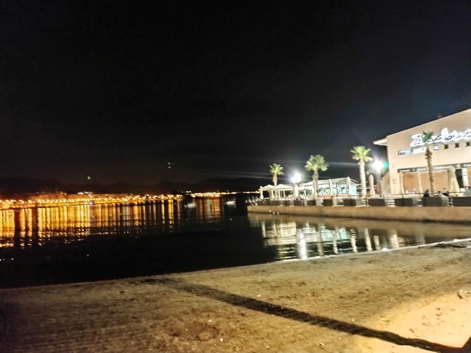 Puerto de Mazarrón beach and bay at night with the town lights reflecting on the water