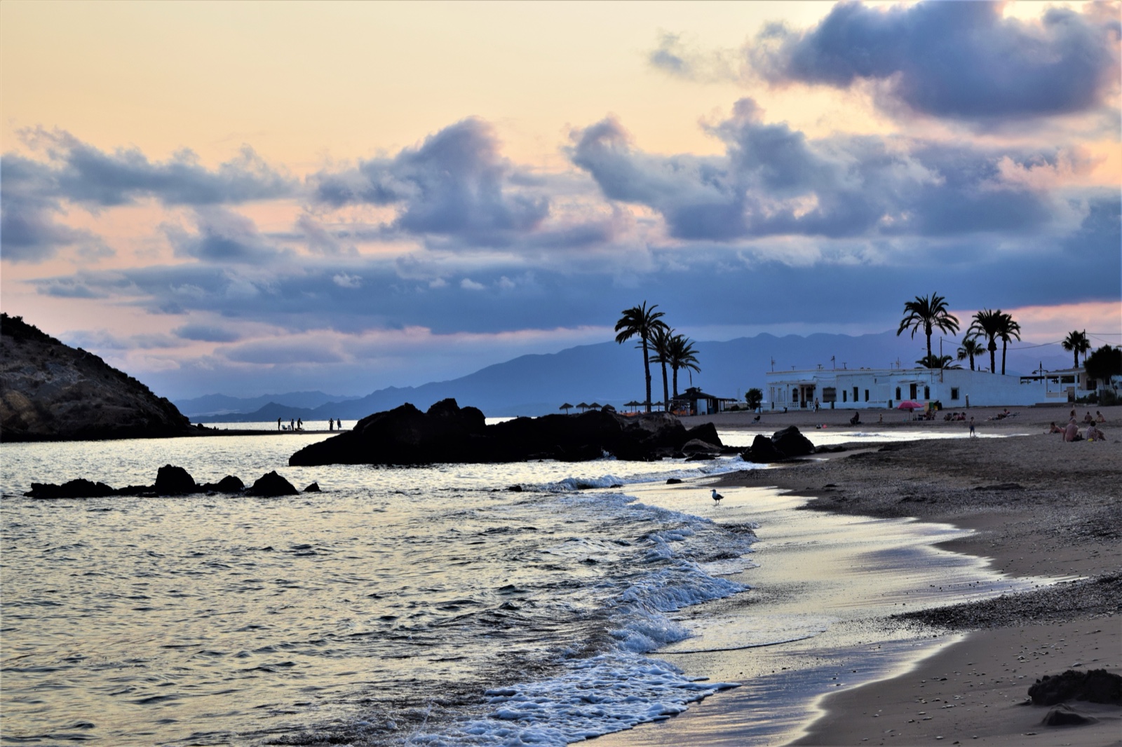 Playa de Nares beach at dusk with palms and mountains