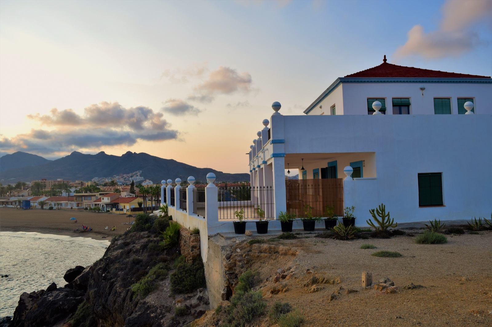 A white villa on the headland at Playa de Nares at dusk