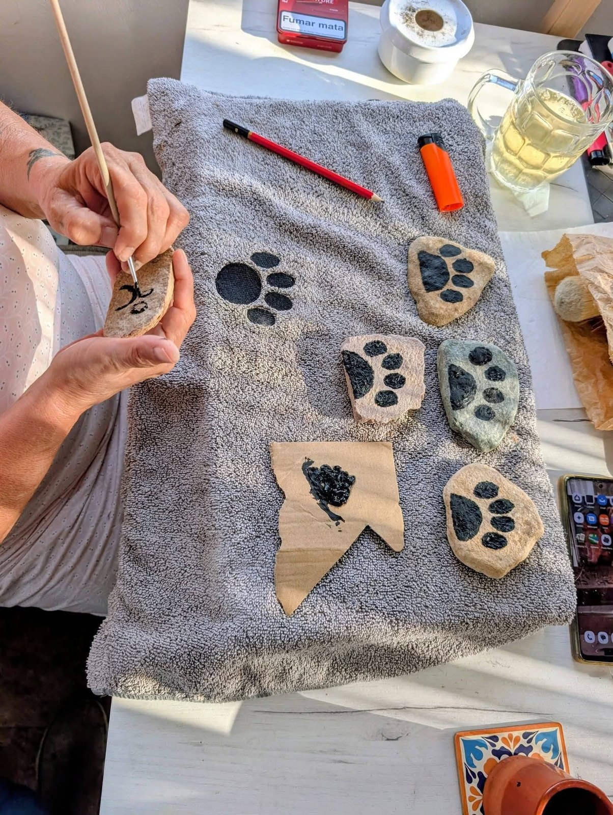 Paw print stones being painted by hand for the remembrance area